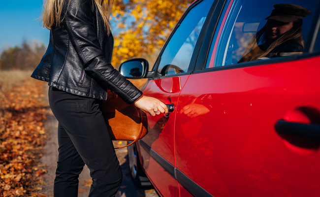 Opening Car Door. Woman Opens Red Car With Key On Autumn Road. D